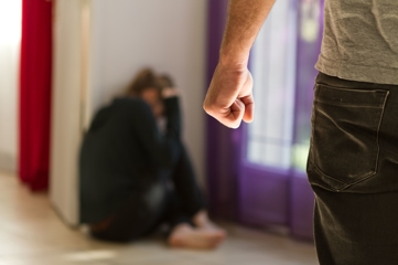 Man with a fist approaching cowering woman - Denton Assault Attorney